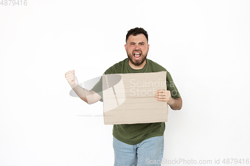 Image of Young man protesting with blank board, sign isolated on white studio background