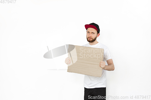 Image of Young man protesting with blank board, sign isolated on white studio background