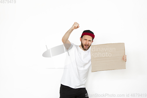 Image of Young man protesting with blank board, sign isolated on white studio background