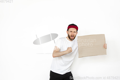 Image of Young man protesting with blank board, sign isolated on white studio background