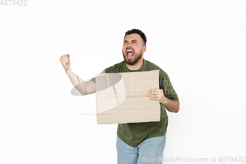 Image of Young man protesting with blank board, sign isolated on white studio background