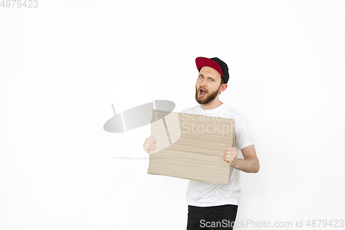 Image of Young man protesting with blank board, sign isolated on white studio background