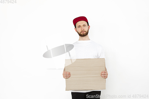 Image of Young man protesting with blank board, sign isolated on white studio background