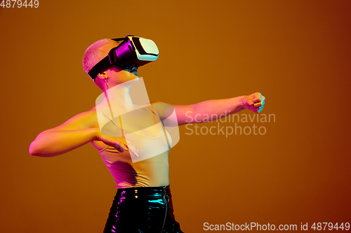 Image of Portrait of young caucasian woman in fashionable eyewear on brown background with copyspace, unusual and freaky appearance