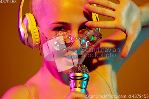 Image of Portrait of young caucasian woman in fashionable eyewear on brown background with copyspace, unusual and freaky appearance