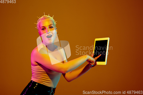 Image of Portrait of young caucasian woman in fashionable eyewear on brown background with copyspace, unusual and freaky appearance