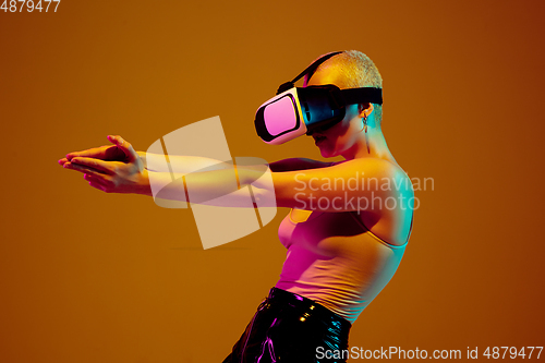 Image of Portrait of young caucasian woman in fashionable eyewear on brown background with copyspace, unusual and freaky appearance