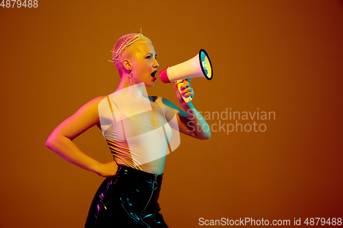 Image of Portrait of young caucasian woman in fashionable eyewear on brown background with copyspace, unusual and freaky appearance