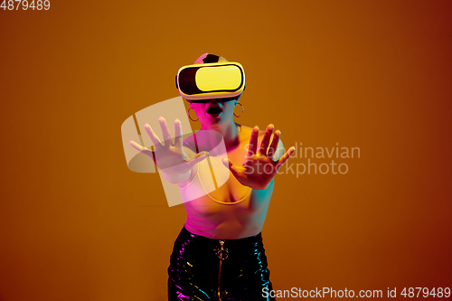 Image of Portrait of young caucasian woman in fashionable eyewear on brown background with copyspace, unusual and freaky appearance