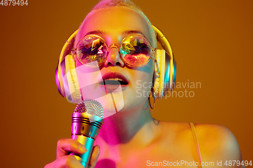 Image of Portrait of young caucasian woman in fashionable eyewear on brown background with copyspace, unusual and freaky appearance