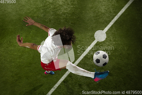 Image of Top view of caucasian football or soccer player on green background of grass in action and motion