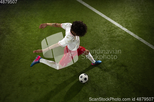 Image of Top view of caucasian football or soccer player on green background of grass in action and motion