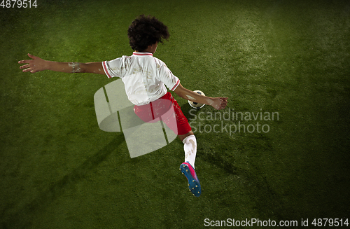 Image of Top view of caucasian football or soccer player on green background of grass in action and motion