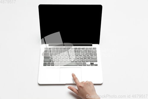 Image of Close up of human hand using laptop with blank black screen, education and business concept