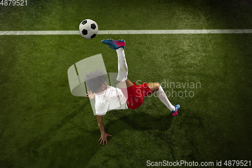 Image of Top view of caucasian football or soccer player on green background of grass in action and motion