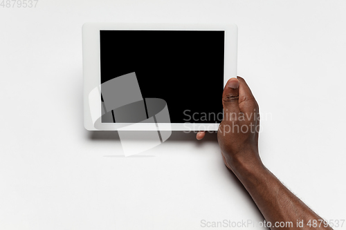 Image of Close up of human hand using tablet with blank black screen, education and business concept