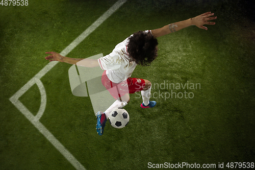 Image of Top view of caucasian football or soccer player on green background of grass in action and motion