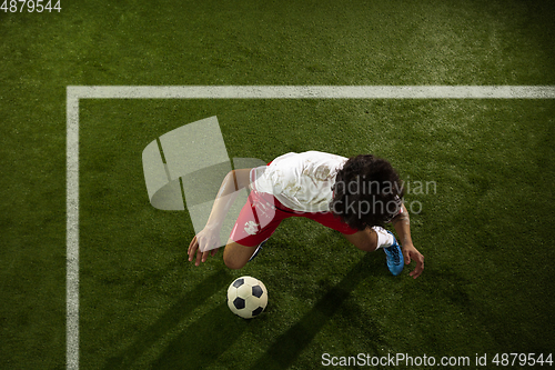 Image of Top view of caucasian football or soccer player on green background of grass in action and motion