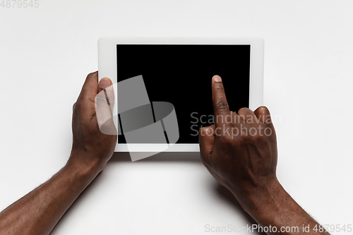 Image of Close up of human hand using tablet with blank black screen, education and business concept
