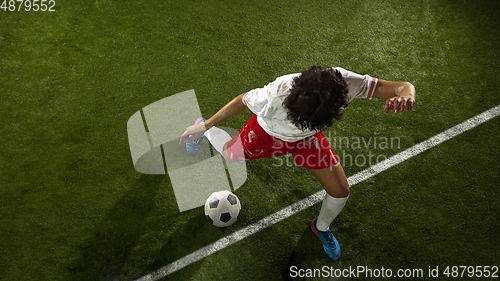 Image of Top view of caucasian football or soccer player on green background of grass in action and motion