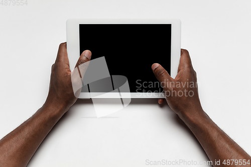 Image of Close up of human hand using tablet with blank black screen, education and business concept