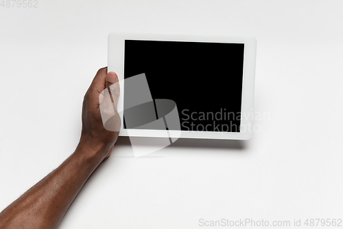 Image of Close up of human hand using tablet with blank black screen, education and business concept