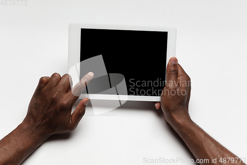 Image of Close up of human hand using tablet with blank black screen, education and business concept