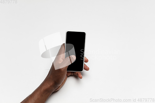 Image of Close up of human hand using smartphone with blank black screen, education and business concept