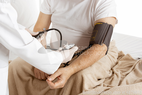 Image of Elderly old man recovering in a hospital bed isolated on white