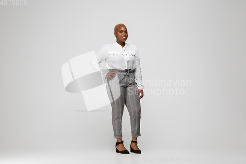 Image of Young african-american woman in office attire on gray background. Bodypositive female character. plus size businesswoman