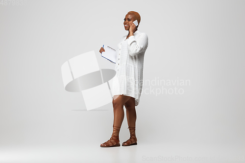 Image of Young african-american woman in casual wear on gray background. Bodypositive female character, plus size businesswoman