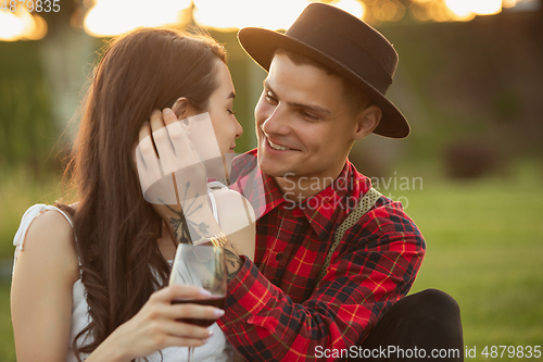 Image of Caucasian young and happy couple enjoying a picnic in the park on summer day