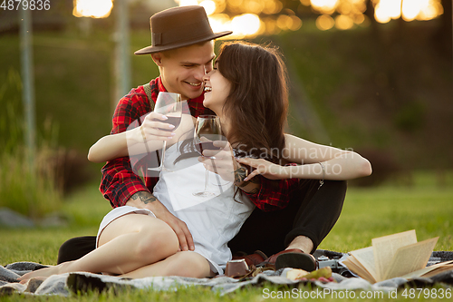 Image of Caucasian young and happy couple enjoying a picnic in the park on summer day