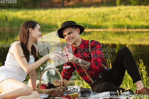 Image of Caucasian young and happy couple enjoying a picnic in the park on summer day