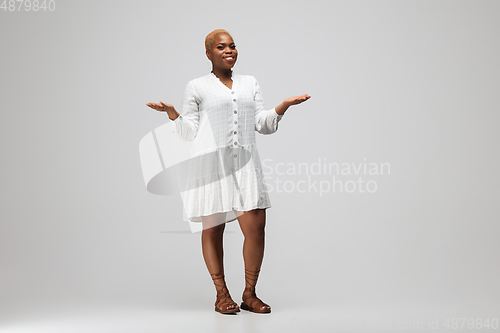 Image of Young african-american woman in casual wear on gray background. Bodypositive female character, plus size businesswoman