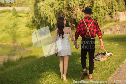 Image of Caucasian young and happy couple enjoying a picnic in the park on summer day