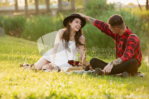 Image of Caucasian young and happy couple enjoying a picnic in the park on summer day