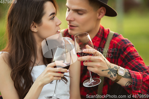 Image of Caucasian young and happy couple enjoying a picnic in the park on summer day