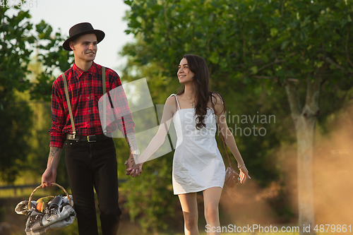 Image of Caucasian young and happy couple enjoying a picnic in the park on summer day