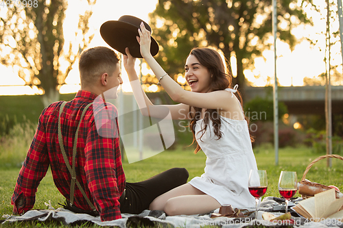 Image of Caucasian young and happy couple enjoying a picnic in the park on summer day