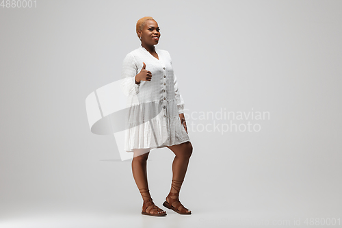 Image of Young african-american woman in casual wear on gray background. Bodypositive female character, plus size businesswoman