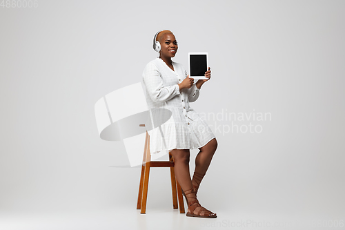 Image of Young african-american woman in casual wear on gray background. Bodypositive female character, plus size businesswoman