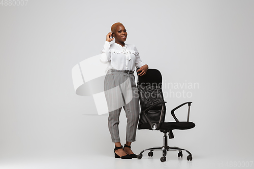 Image of Young african-american woman in office attire on gray background. Bodypositive female character. plus size businesswoman