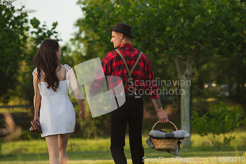 Image of Caucasian young and happy couple enjoying a picnic in the park on summer day