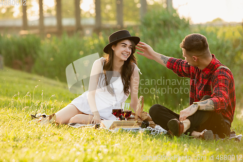 Image of Caucasian young and happy couple enjoying a picnic in the park on summer day