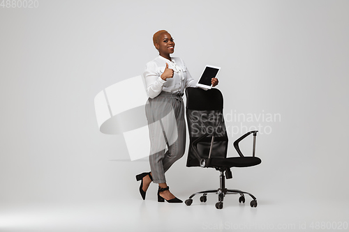 Image of Young african-american woman in office attire on gray background. Bodypositive female character. plus size businesswoman