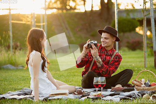 Image of Caucasian young and happy couple enjoying a picnic in the park on summer day