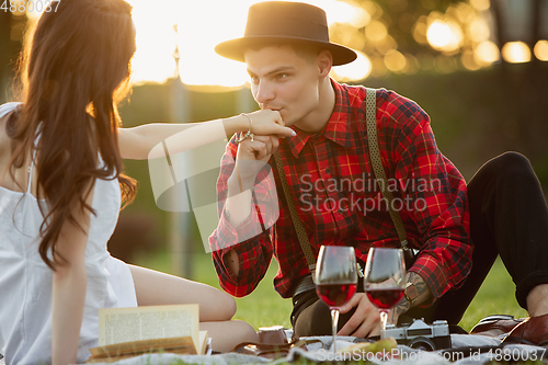 Image of Caucasian young and happy couple enjoying a picnic in the park on summer day
