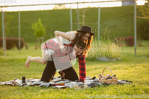 Image of Caucasian young and happy couple enjoying a picnic in the park on summer day