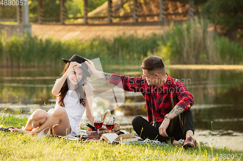 Image of Caucasian young and happy couple enjoying a picnic in the park on summer day